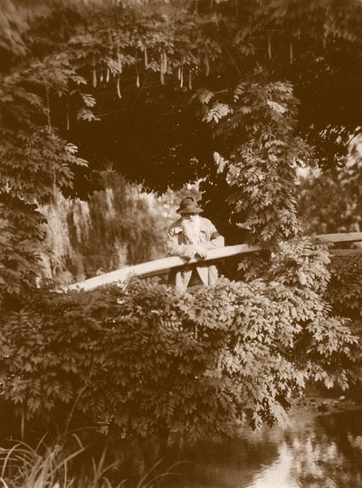 Claude Monet on the Japanese Bridge in his garden at Giverny, c.1920 by French Photographer